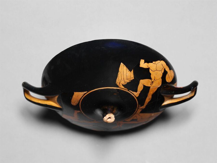 Red-figure drinking cup with a nude athlete painted on its outer wall