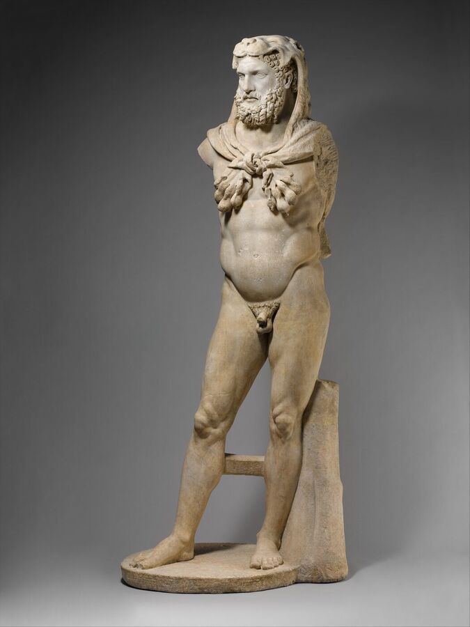 Life-size Roman marble statue of a bearded, muscular nude man standing with a lion skin draped over his head and shoulders