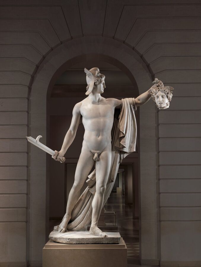 Life-size white marble statue of the naked hero Perseus holding up the severed head of Medusa in one hand and a sword in the other