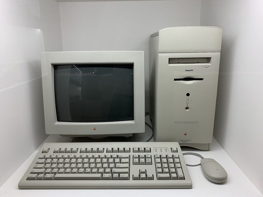 Beige Apple Macintosh desktop computer from 1996 with its monitor, keyboard and mouse, displayed in a museum case