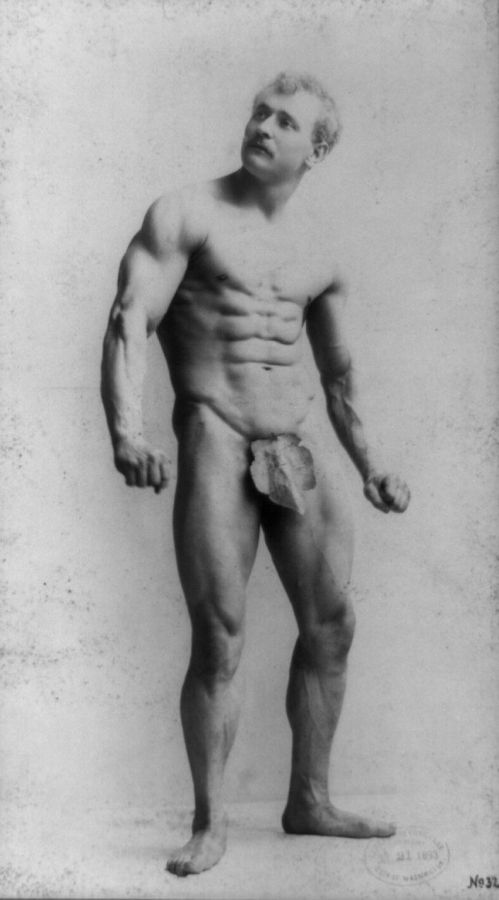 Photograph of the moustached strongman Eugen Sandow standing naked except for a fig leaf, fists clenched, looking upwards
