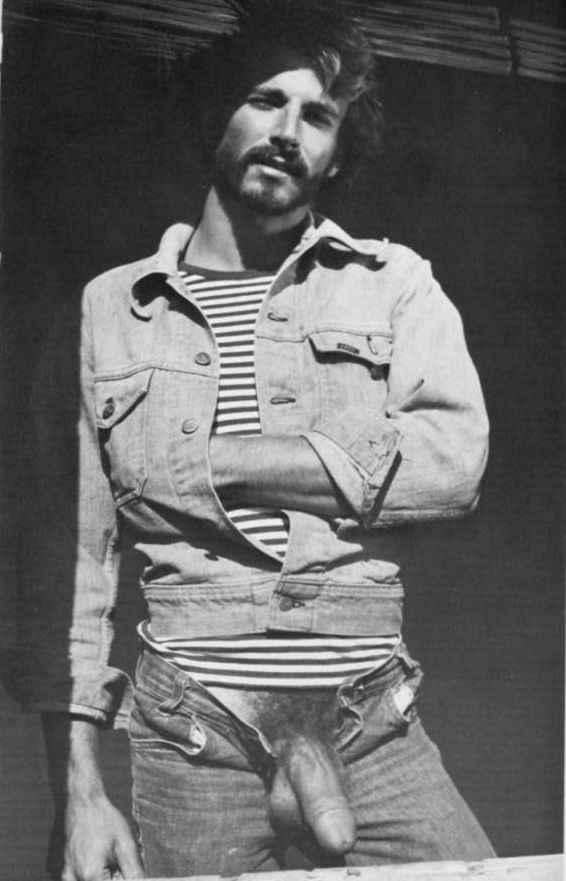 Black and white photograph of Al Parker in a denim jacket and striped T-shirt with his jeans open