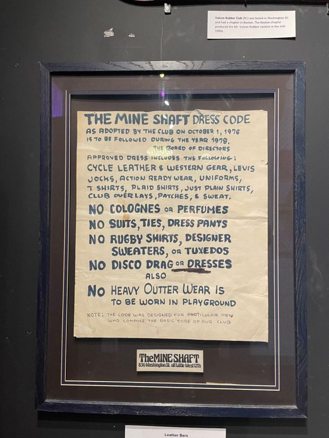 A framed hand-lettered sign headed The Mine Shaft Dress Code, listing approved clothing and forbidden items such as colognes, suits, rugby shirts and disco drag